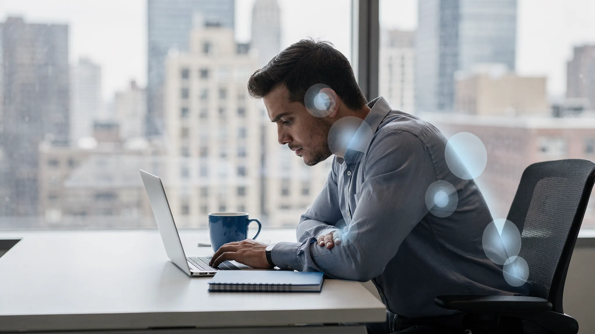 A NYC office worker at a desk with a laptop, showing common slouched posture with forward head and rounded shoulders, with a simple overlay highlighting neck, upper back, and low back strain points.
